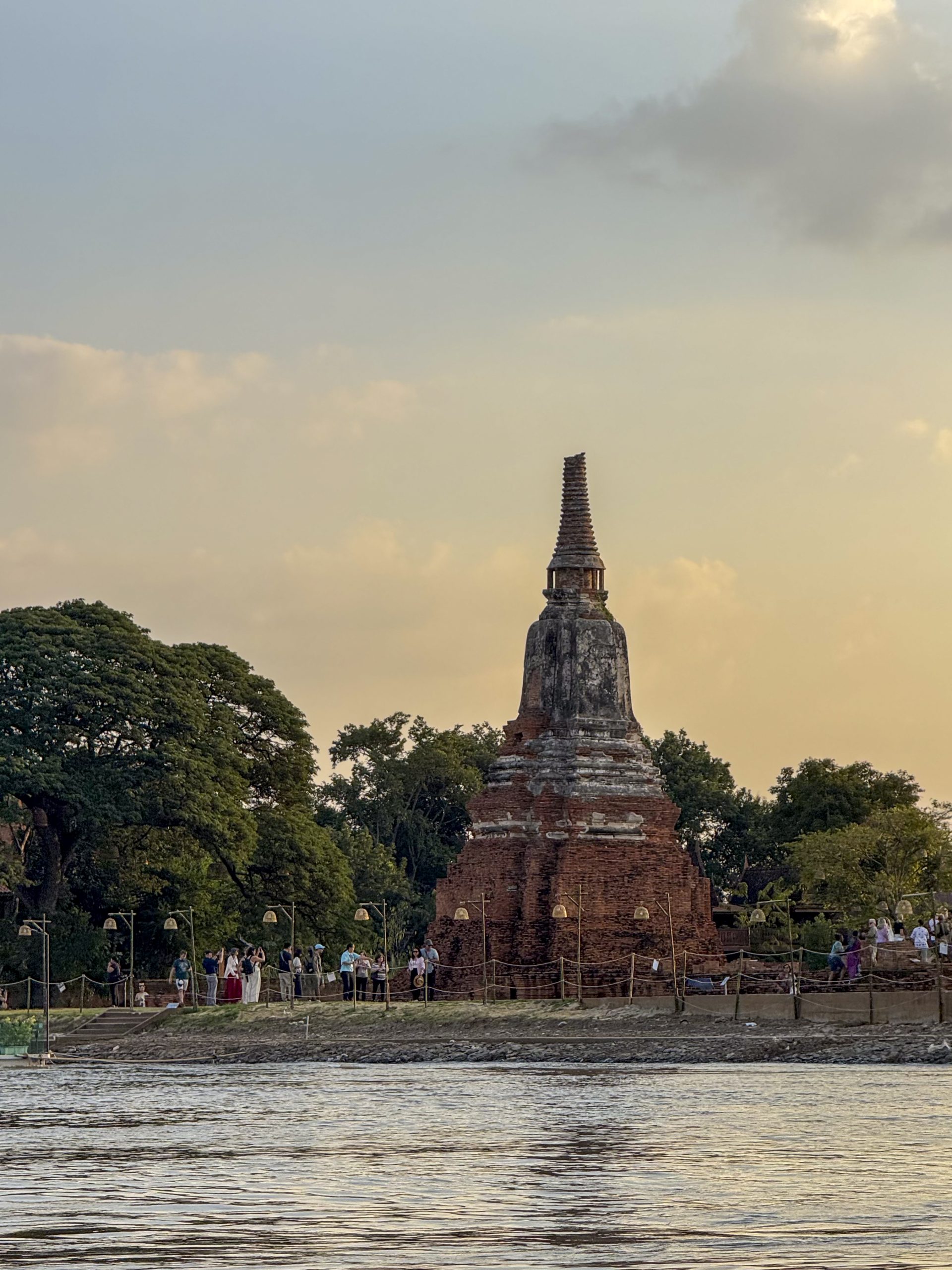 Bangkok, Thailand - November 11, 2024: Wat Chaiwatthanaram Ayutthaya temple seen from river boat, ancient famous brick towers under a golden sunset. Traditional heritage, culture.